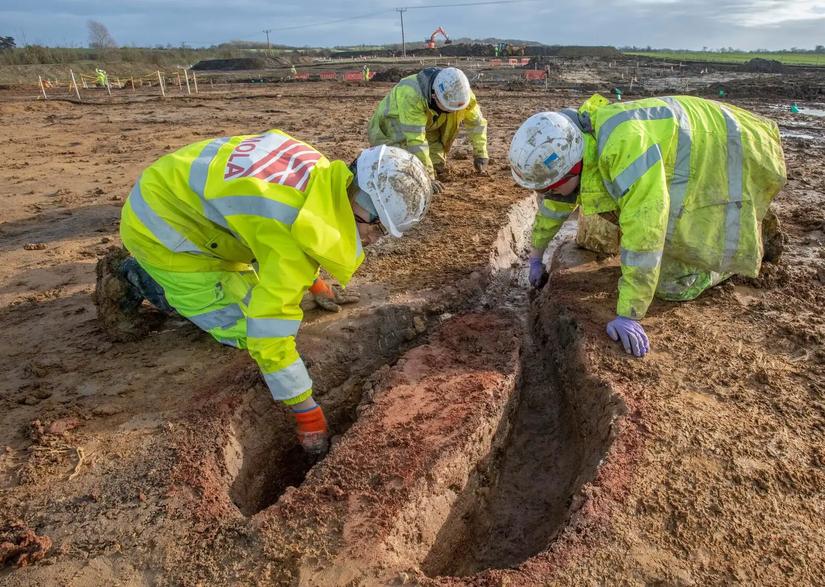 three archaeologists excavating a kiln
