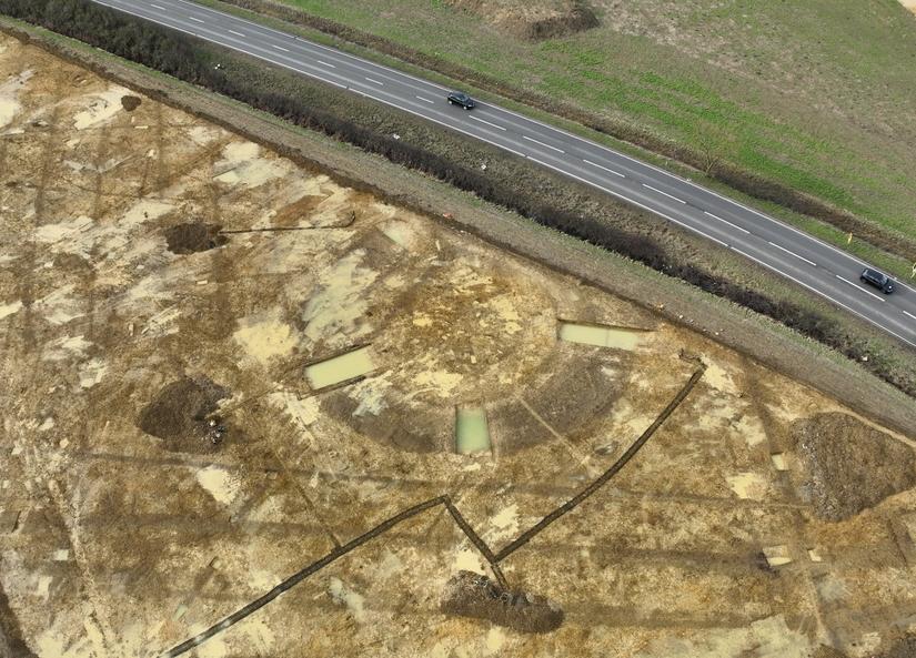 Aerial photopgraph of archaeological excavations, a large circular outline of a ditch can be seen