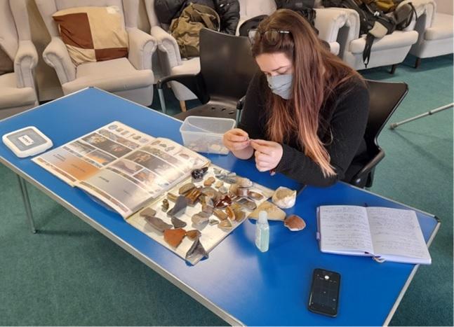 Photo of woman examining pieces of pottery