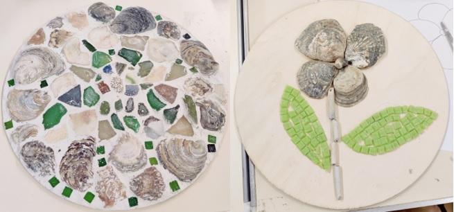 Photo of two circular mosaics, including a flower design with shells for petals.